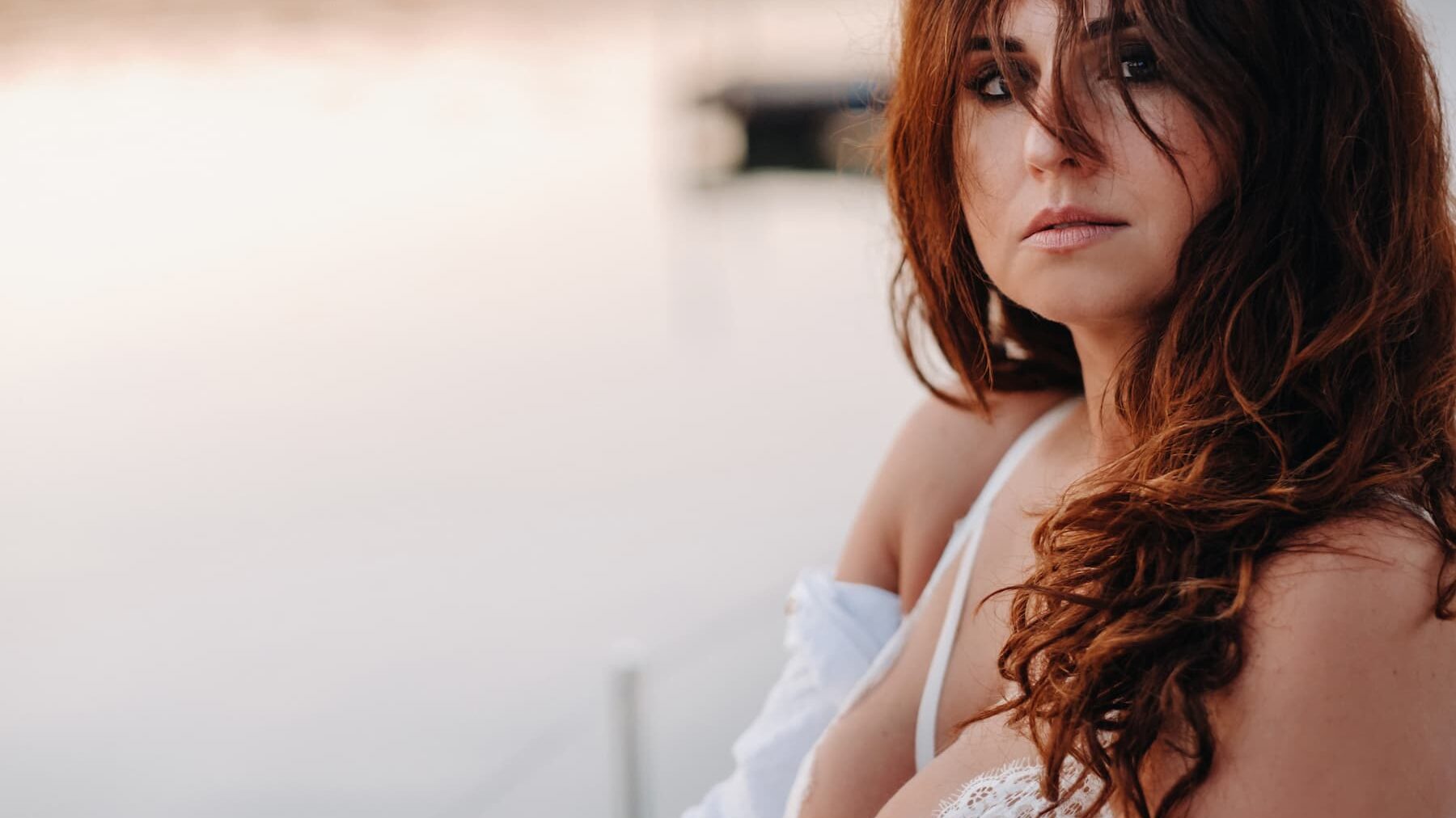 Sexy woman in a white shirt enjoys the sunset.
